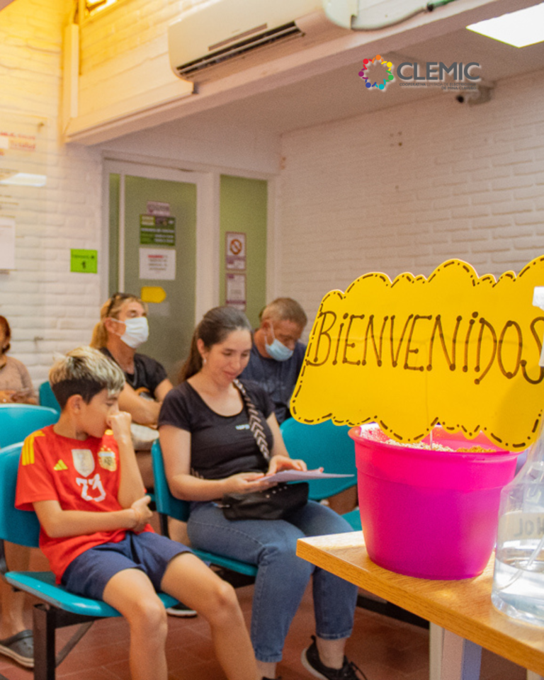 Una madre con su hijo al lado ven el celular e sentados en la sala de espera de Clínica CLEMiC